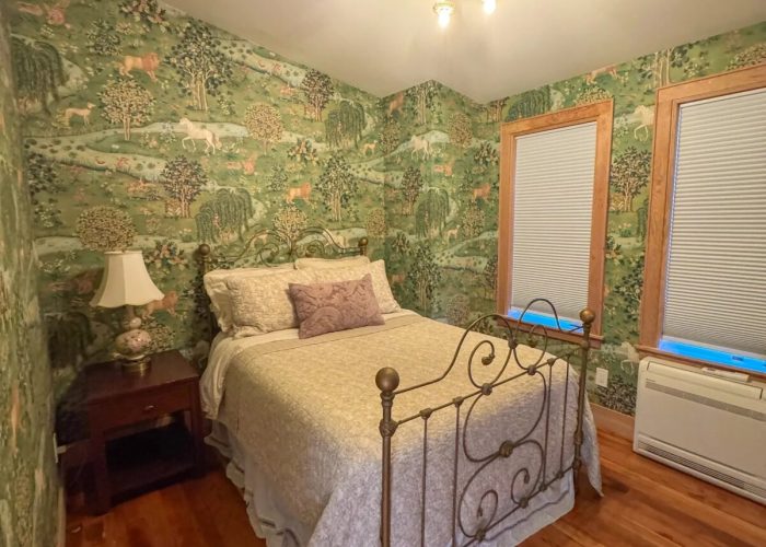 Finished bedroom #2 decorated with green wall paper and fully furnished.