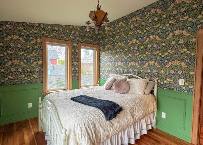 Finished bedroom #3 decorated with green wainscoting and green wall paper.