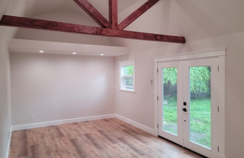 Inside a bright detached accessory dwelling unit (DADU) with exposed ceiling beam.