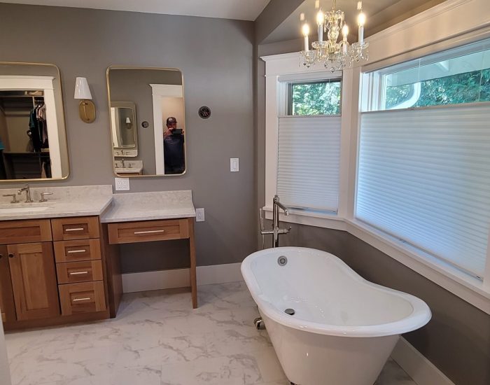 Bathroom remodel with free standing tub near large windows.