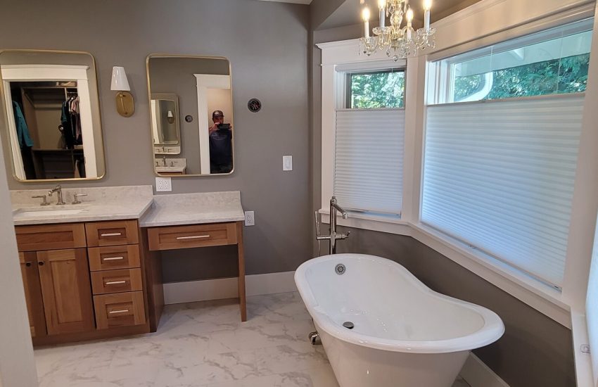 Bathroom remodel with free standing tub near large windows.
