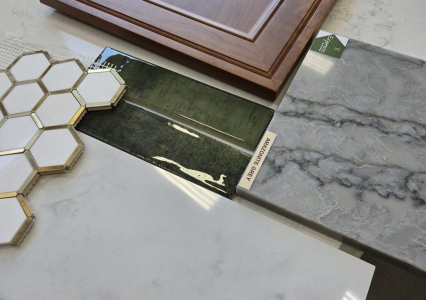 A sample of different finishes for a bathroom remodel including green tile, wood for cabinets and quartz for countertops.