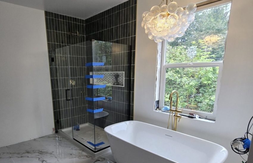 Bathroom addition in Snohomish with free standing tub and green tiled shower.
