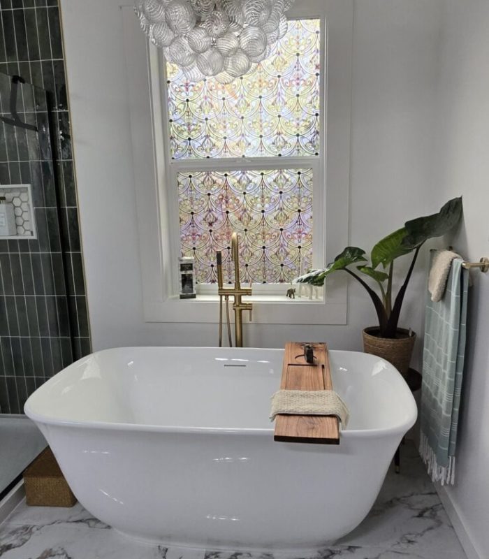Beautiful luxury bathroom remodel with free standing tub, quartz tile flooring, and a unique light fixture.