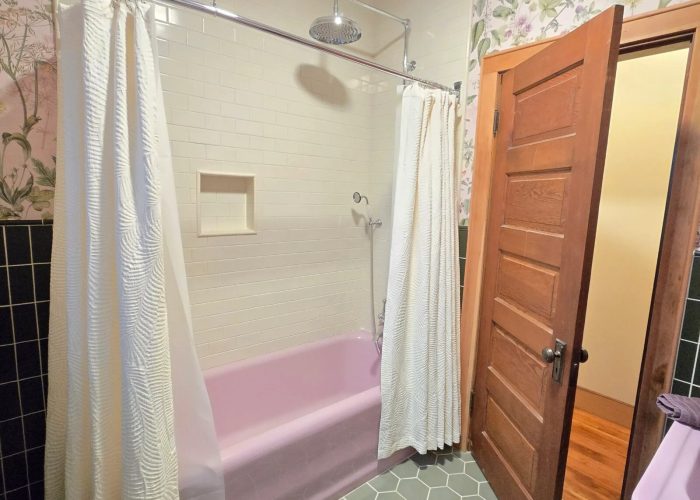 Finished addition's new bathroom with pink reclaimed tub, sink and toilet.
