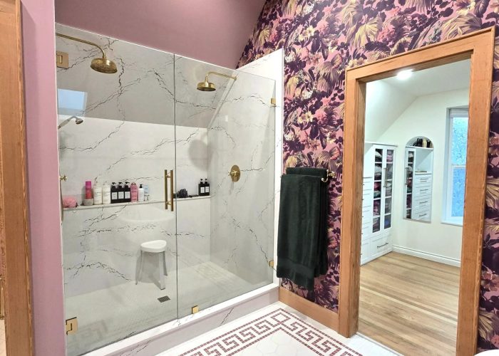 Finished bathroom with Cambria slab shower with dual heads and fire & clay tile.