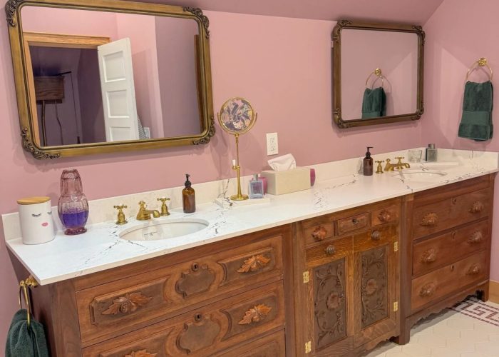 Customized reclaimed and refinished antique vanity cabinets with Cambria slab countertop.