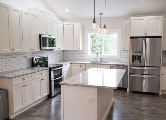 A full kitchen remodel in Snohomish with white cabinets, grey granite countertop and stainless steel appliances.